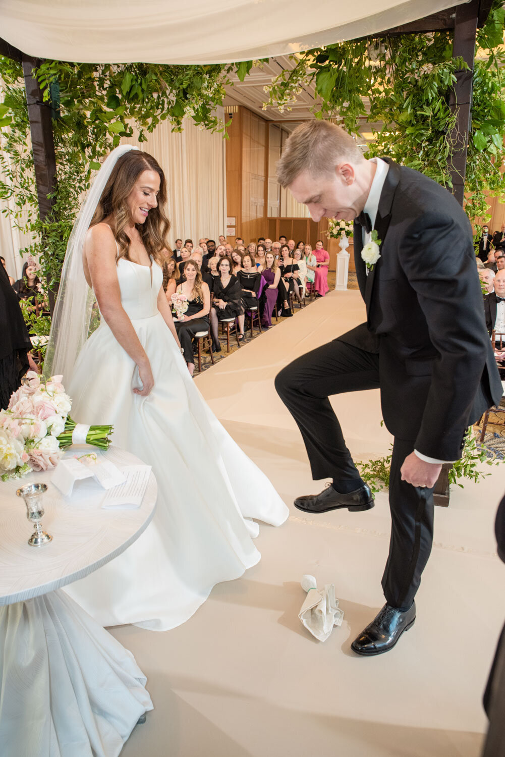A bride and groom are standing in front of a crowd at their wedding