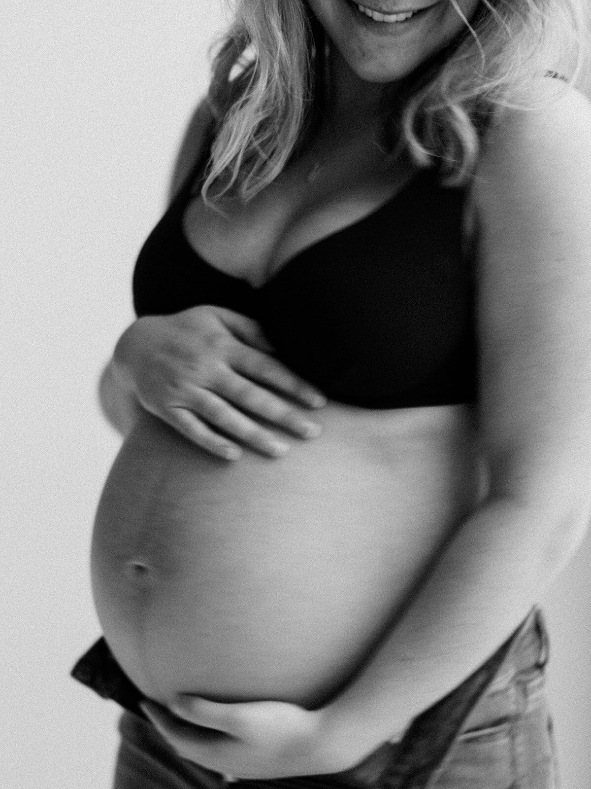 Black and white photo of a woman's pregnant belly