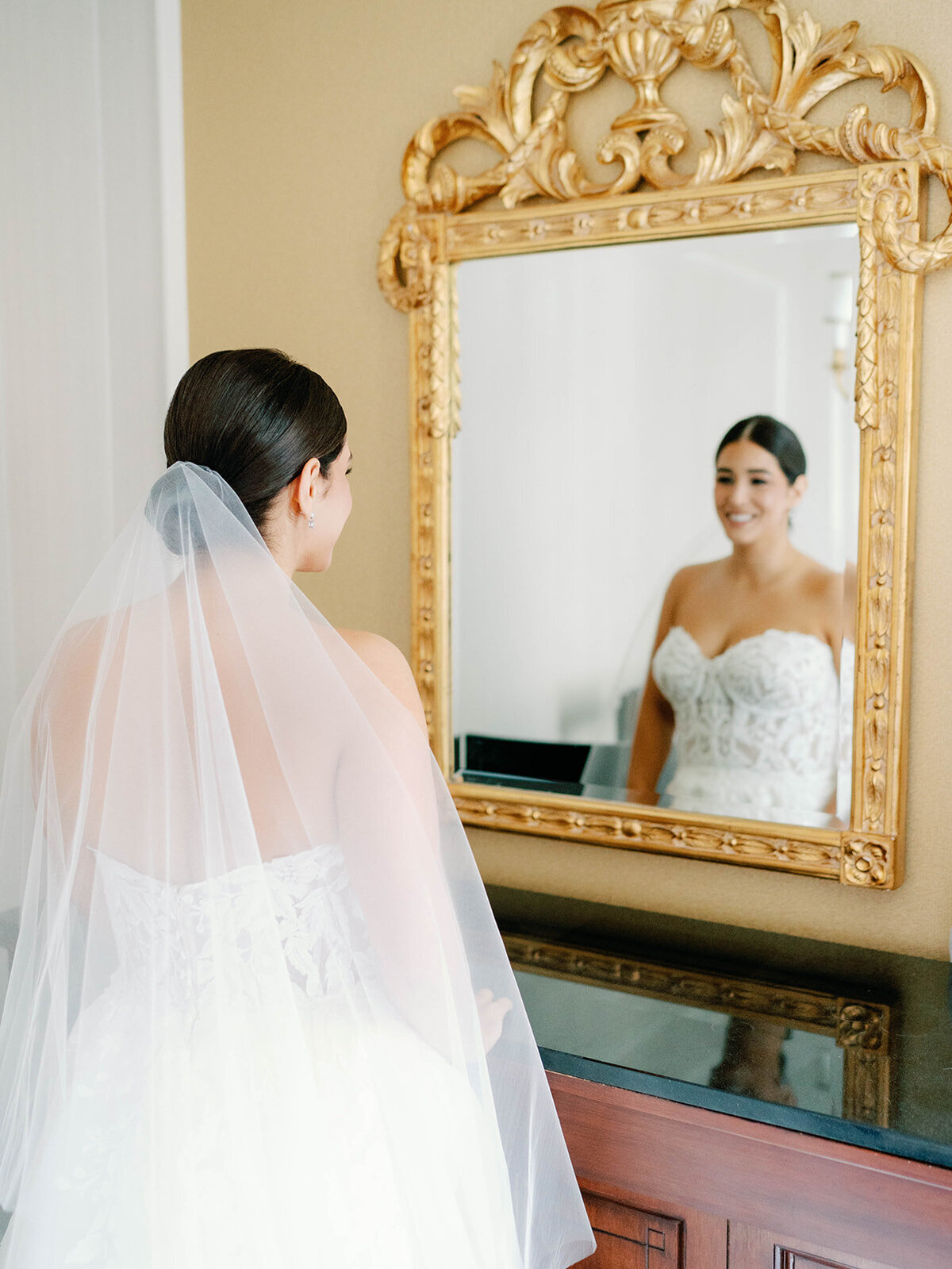 Bride admiring herself in the mirrow at the willard
