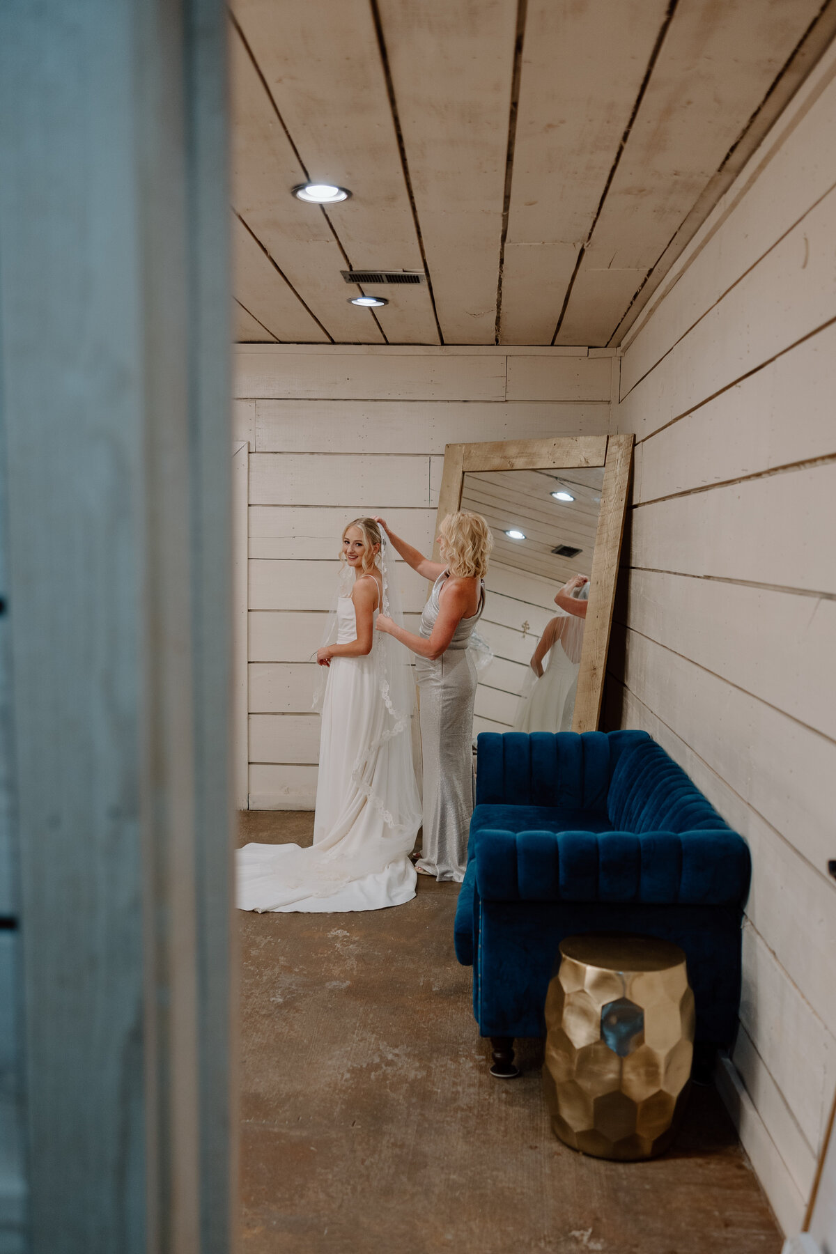 Mother of the bride assists the bride with her veil