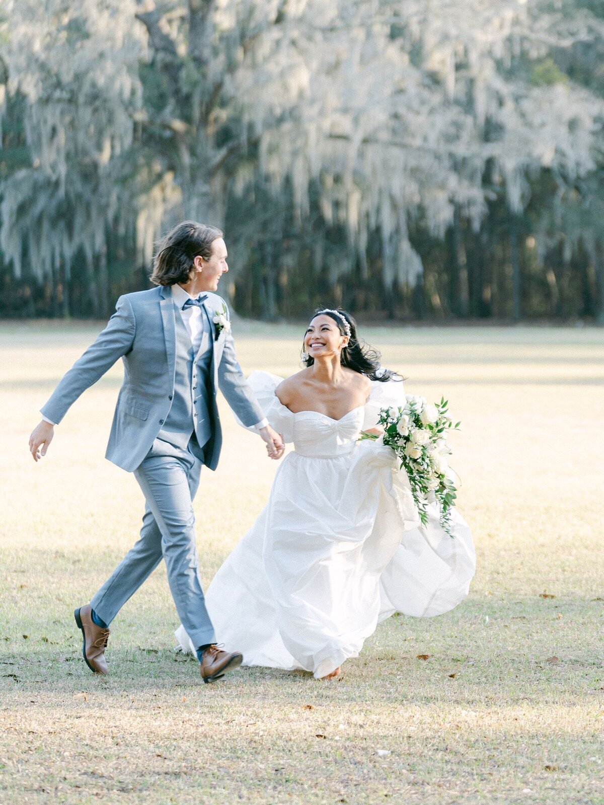 bride and groom running across a field at Hewitt Oaks wedding venue in Bluffton, SC