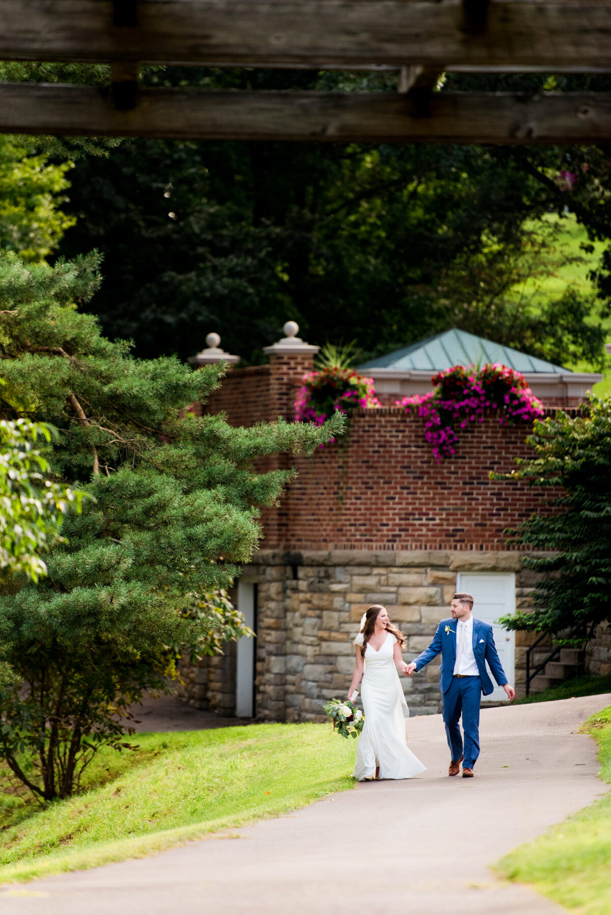 wedding photo couple walking hand in hand down the pathway at oglebay resort wheeling west virginia