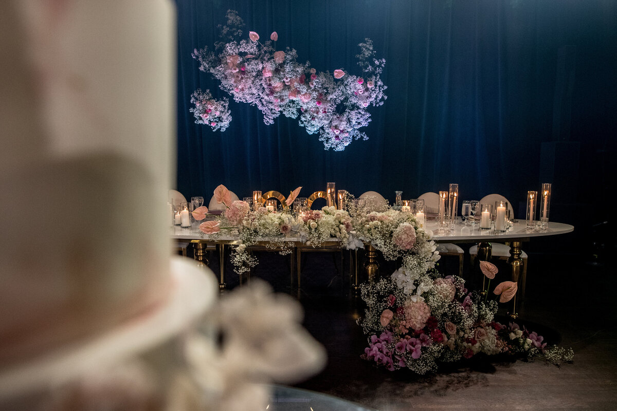A sweetheart table at Theatre St James is decorated with colourful suspended flower arrangements.