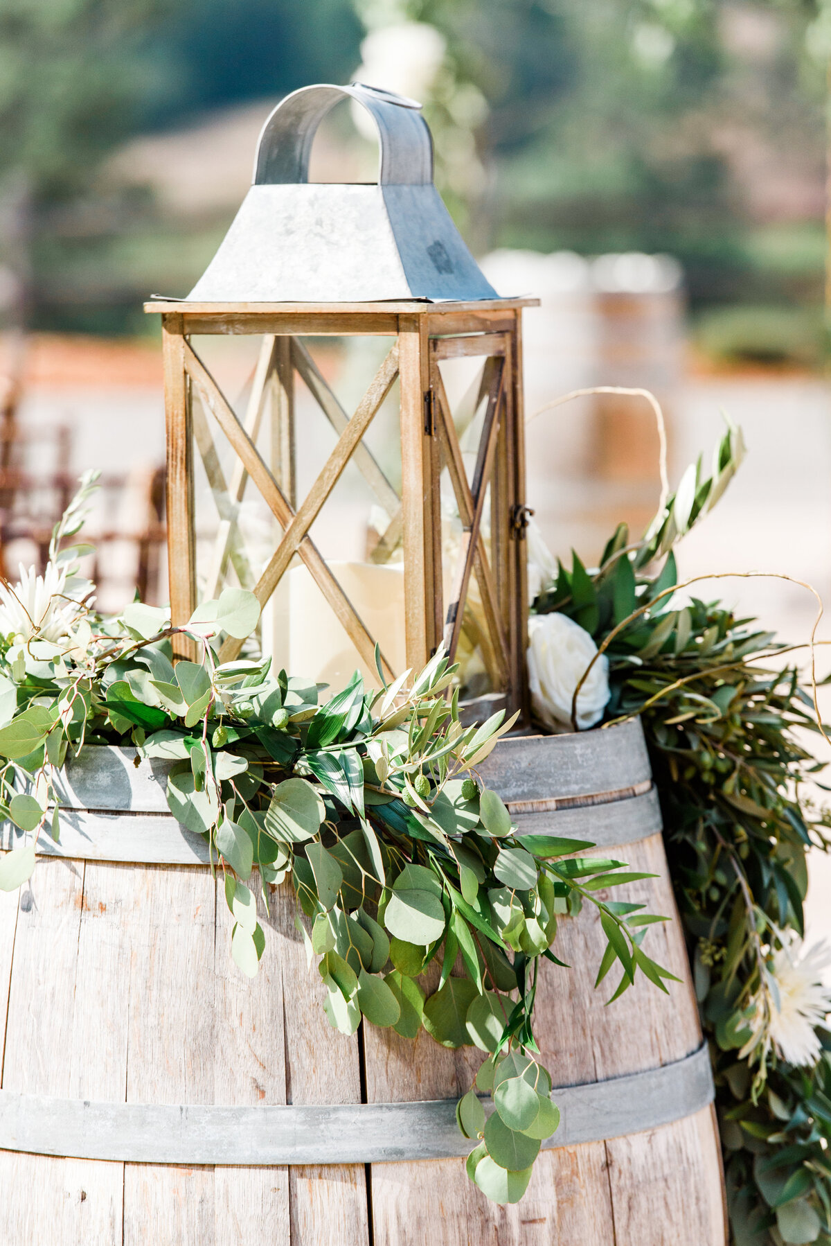 a wine barrel with a lantern and green garland