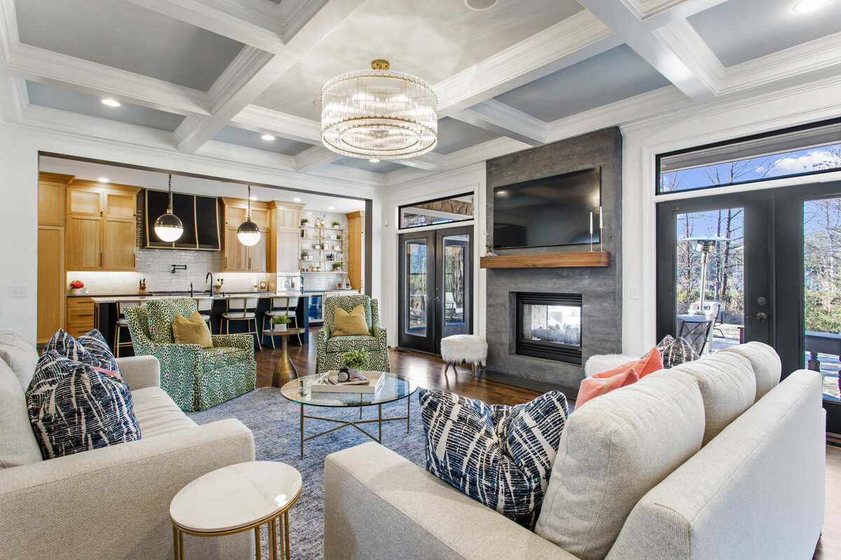 Living room with accent tV panel in gray on white walls and green accent chairs
