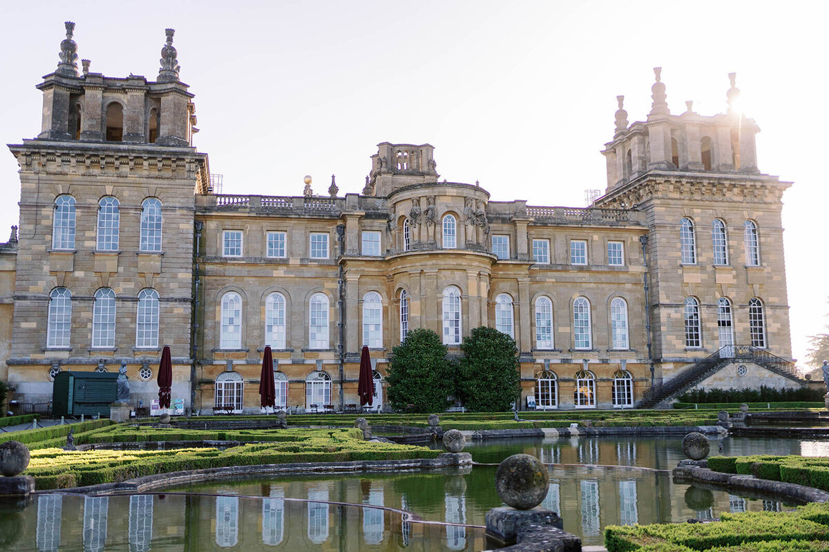 facade of blenheim palace taken from the water terraces with the palace reflected in the water for a luxury event by westacott weddings and events