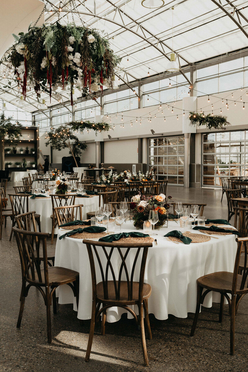 Vintage wedding reception decor with rich jewel tones and greenery.