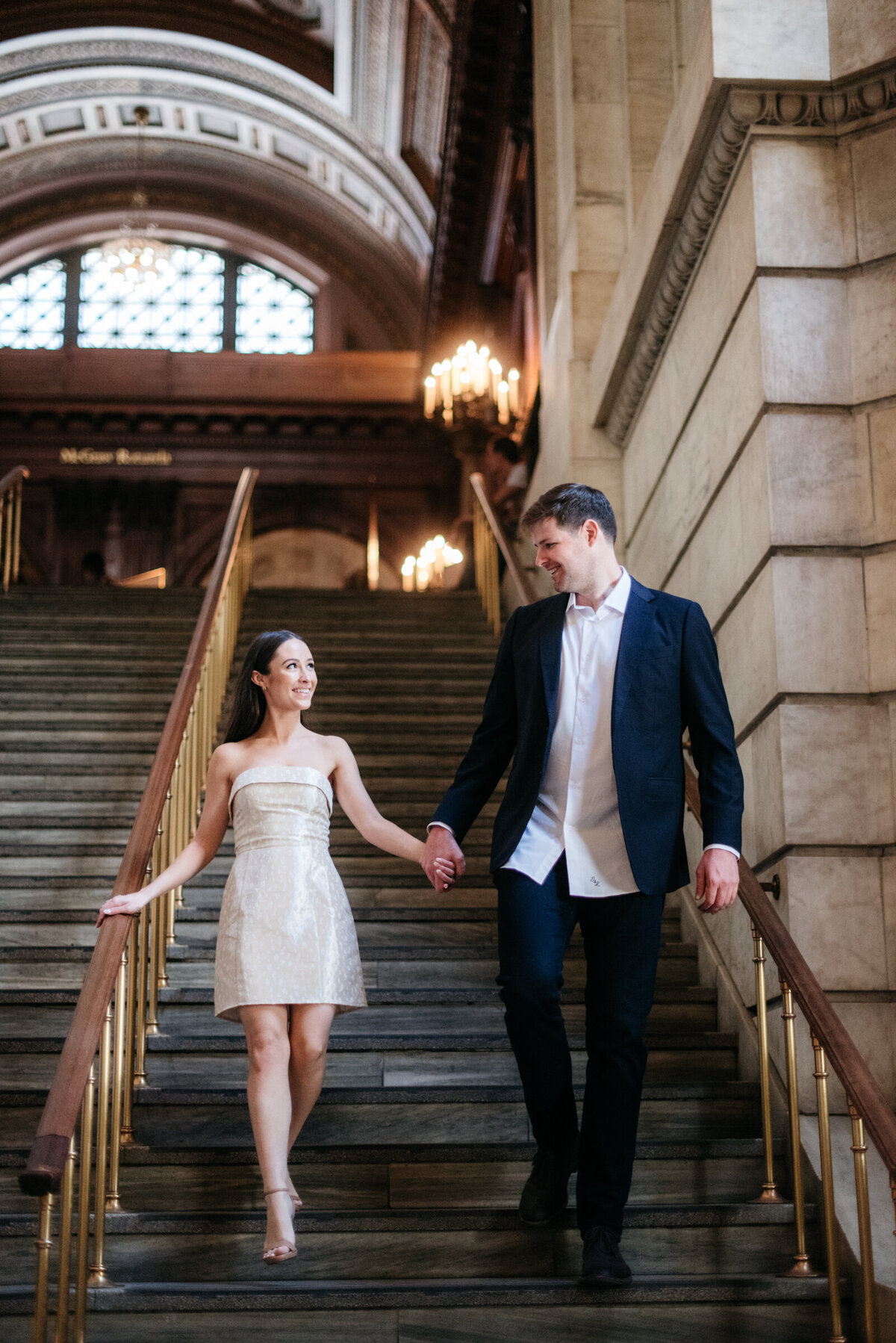 couple walking together on the steps at the new york public library