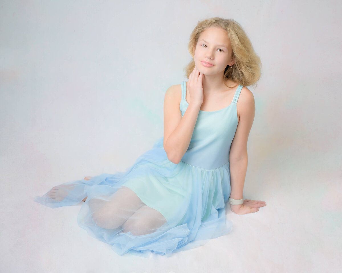 An in home studio-like family photo session with white and pastel blue tones.