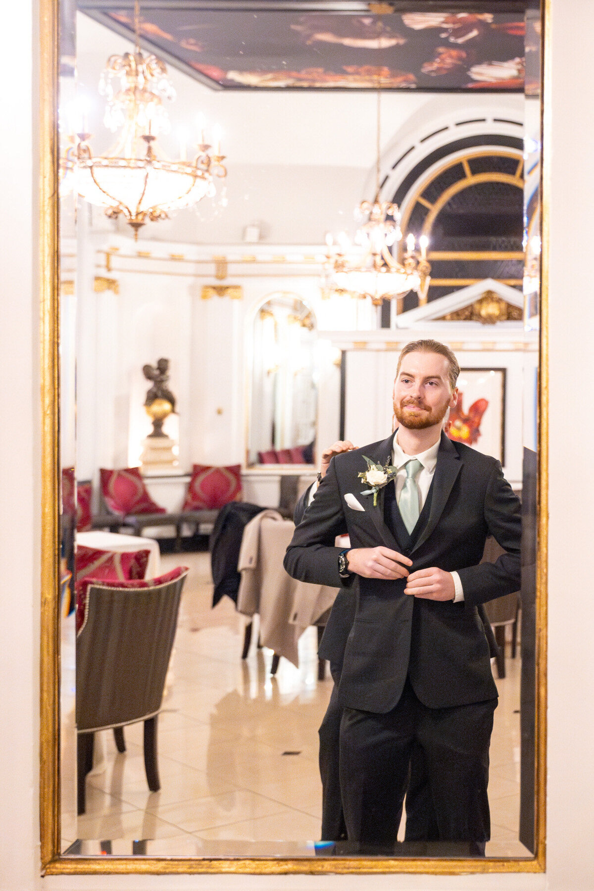 Groom buttoning his tuxedo before the ceremony