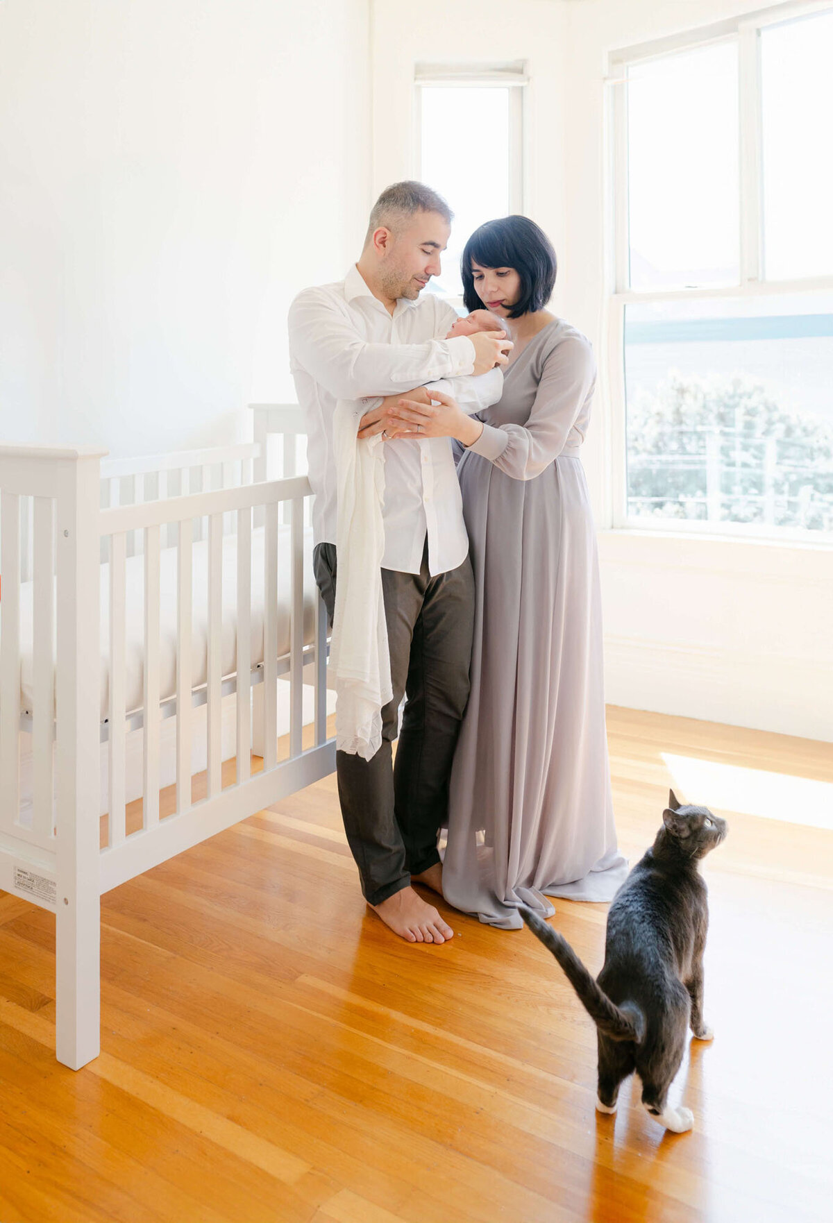 Parents cuddling their newborn during an in-home San Francisco Bay Area newborn photographer session.