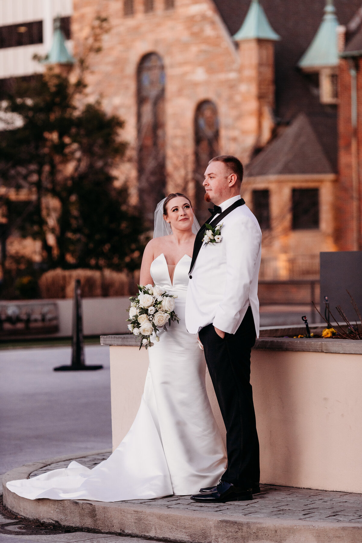 bride looks up at her groom as she holds her bouquet