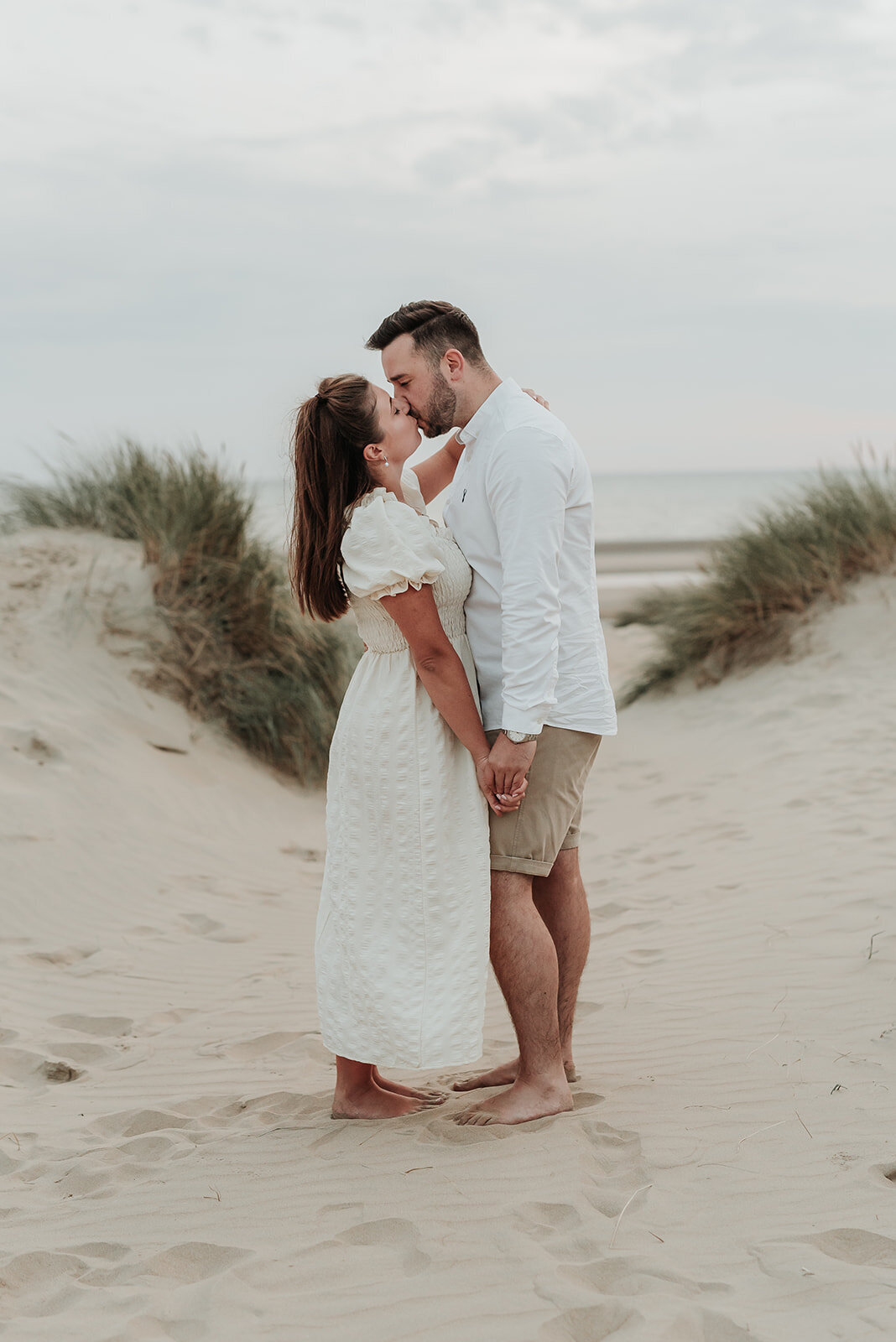 Couple kiss softly on the beach at Camber Sands, Rye