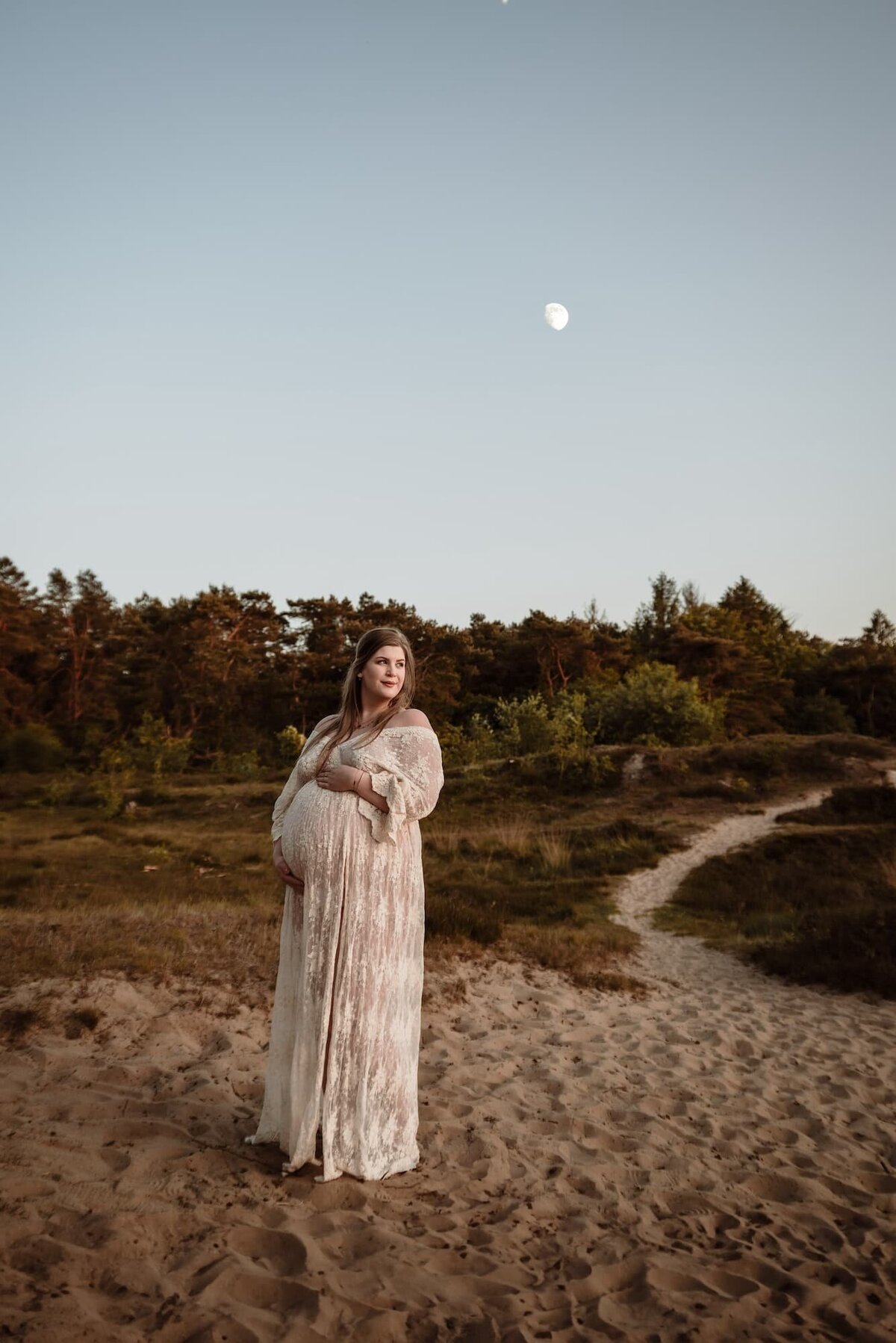 Zwangere vrouw tijdens zwangerschapsshoot in de duinen