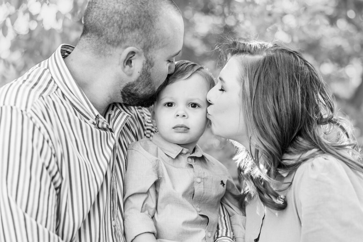 mom-and-dad-kissing-baby-boys-cheeks-in-black-and-white