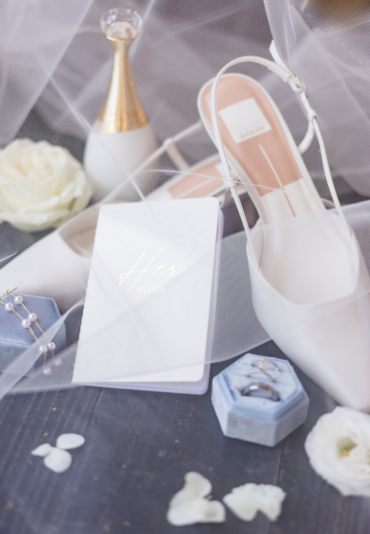 Mesmerizing Bridal details feature her vow book, wedding rings and wedding shoes under her veil to give a romantic look to the picture