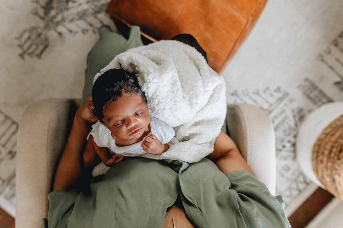 Family photoshoot with a mom holds newborn against her chest