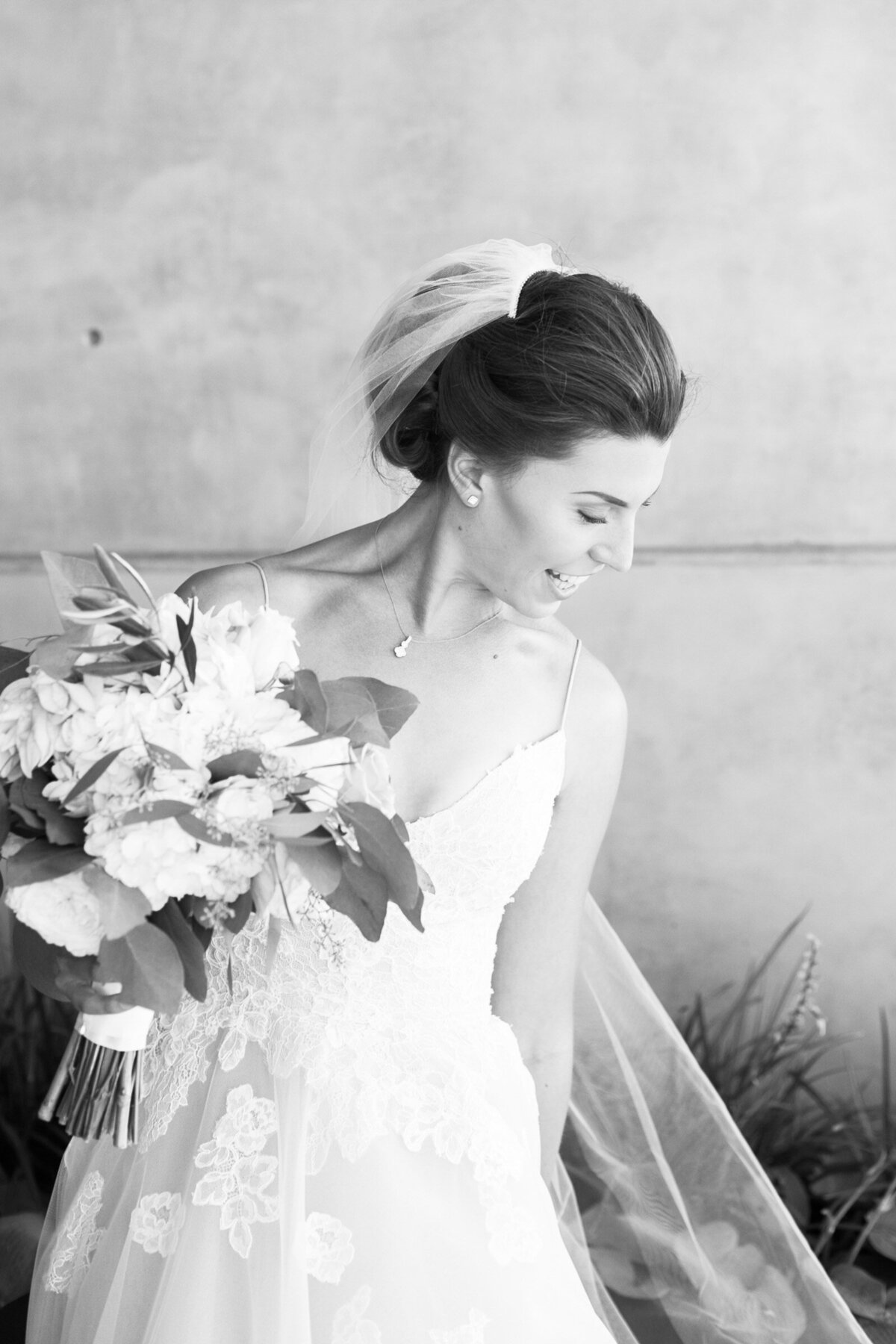 luxury bride holding bouquet laughing outside of ponzi winery