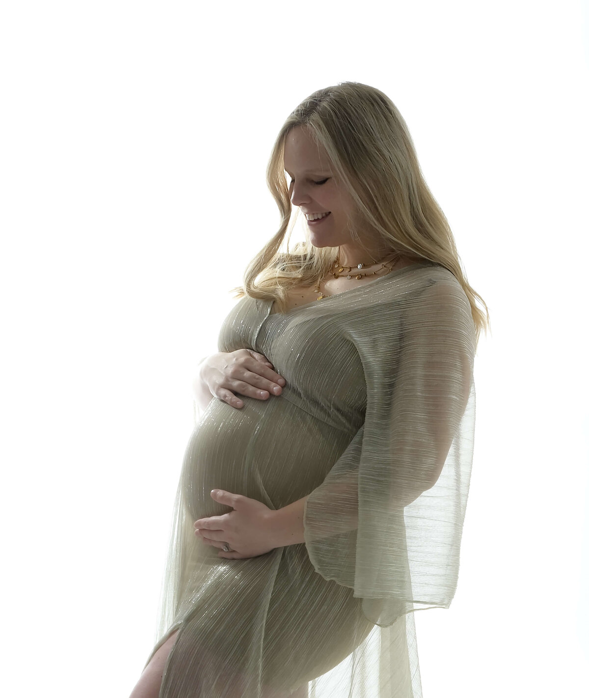 A side profile accentuates this expectant mother's  baby bump while wearing a sheer flowing golden robe. Photo by Beth Benecki.