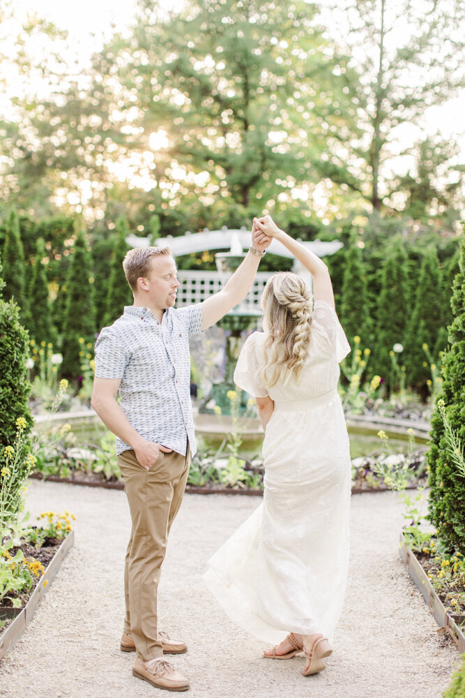 a man twirling a woman in a garden