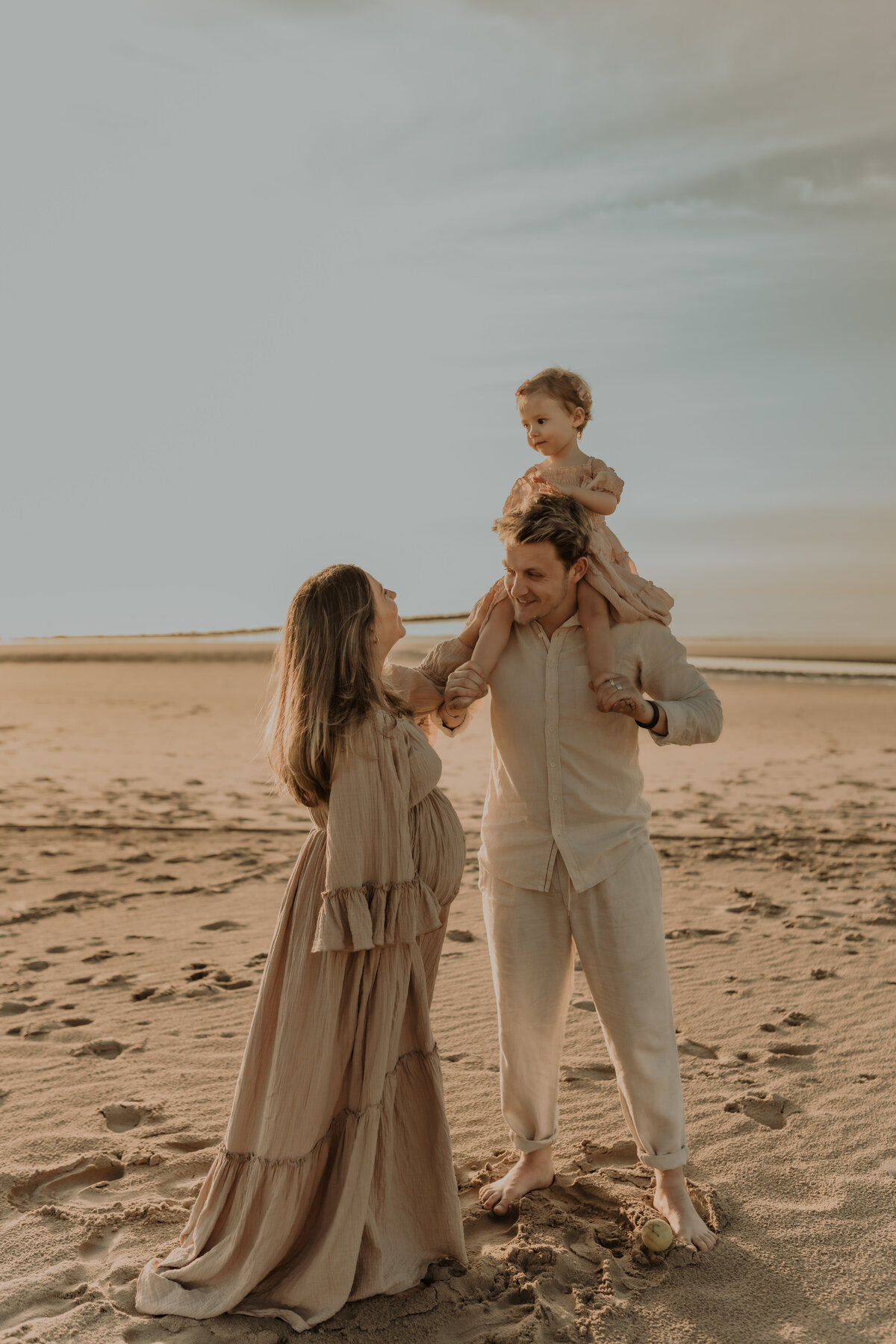 Gezin poseert tijdens familie fotoshoot op het strand