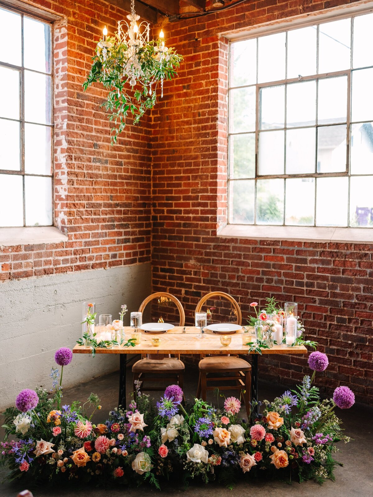 Sweetheart table with peach, pink, orange, and purple  flowers at Moss Denver.