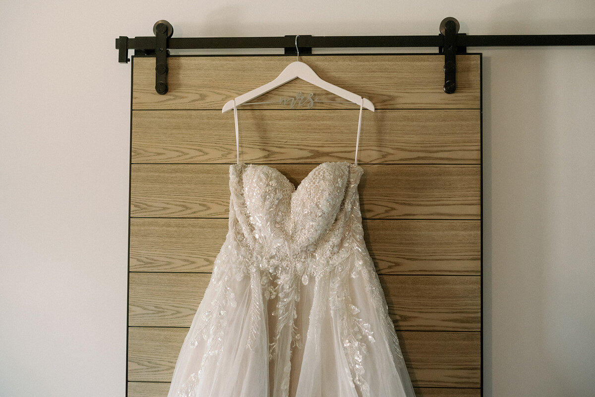 Lace strapless wedding dress hanging on the wedding day.