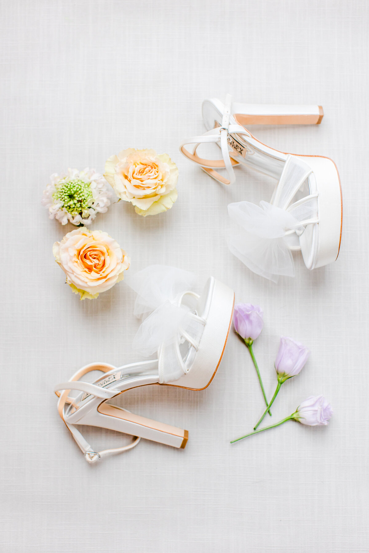 white wedding shoes and purple flowers