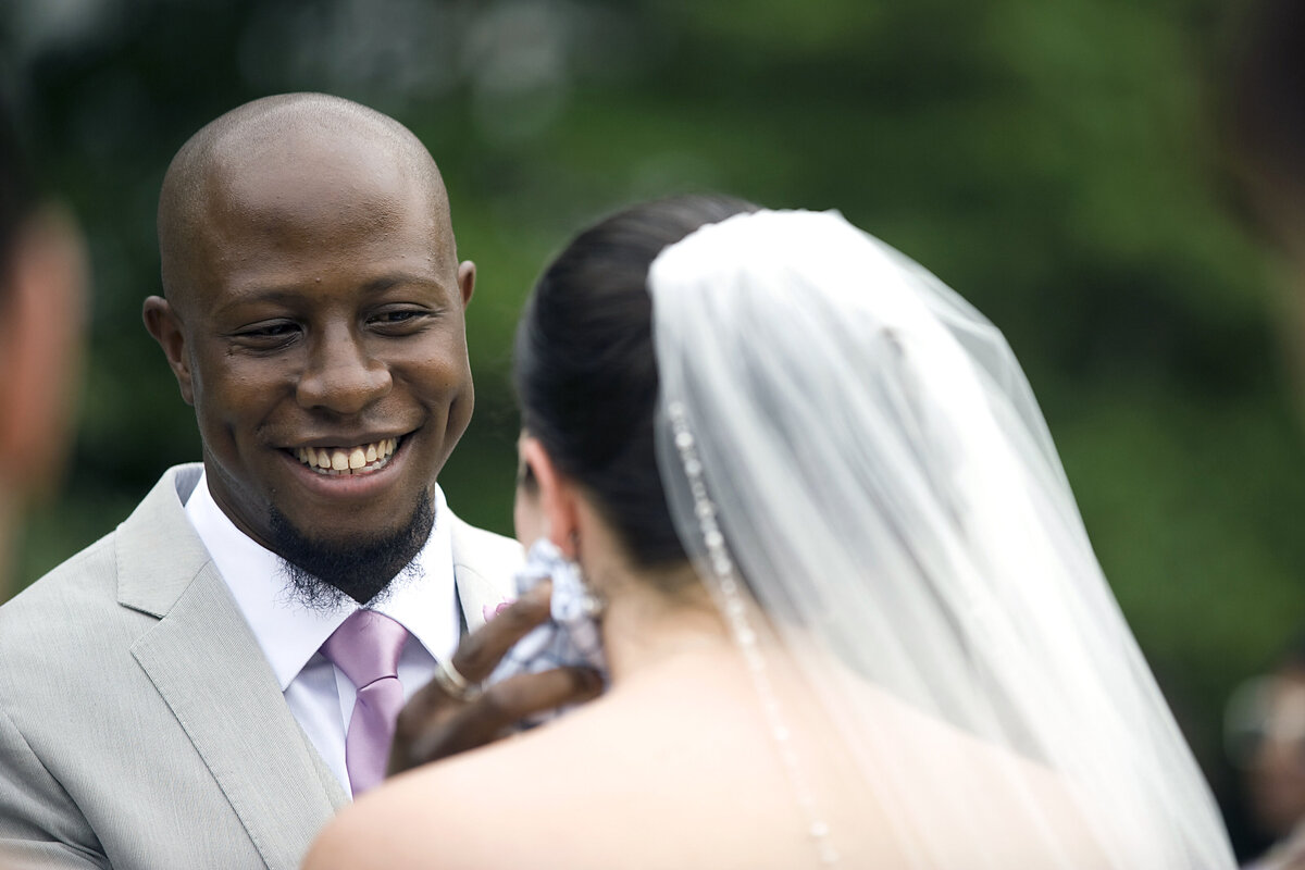A person reaching towards their partner's cheek during their wedding 