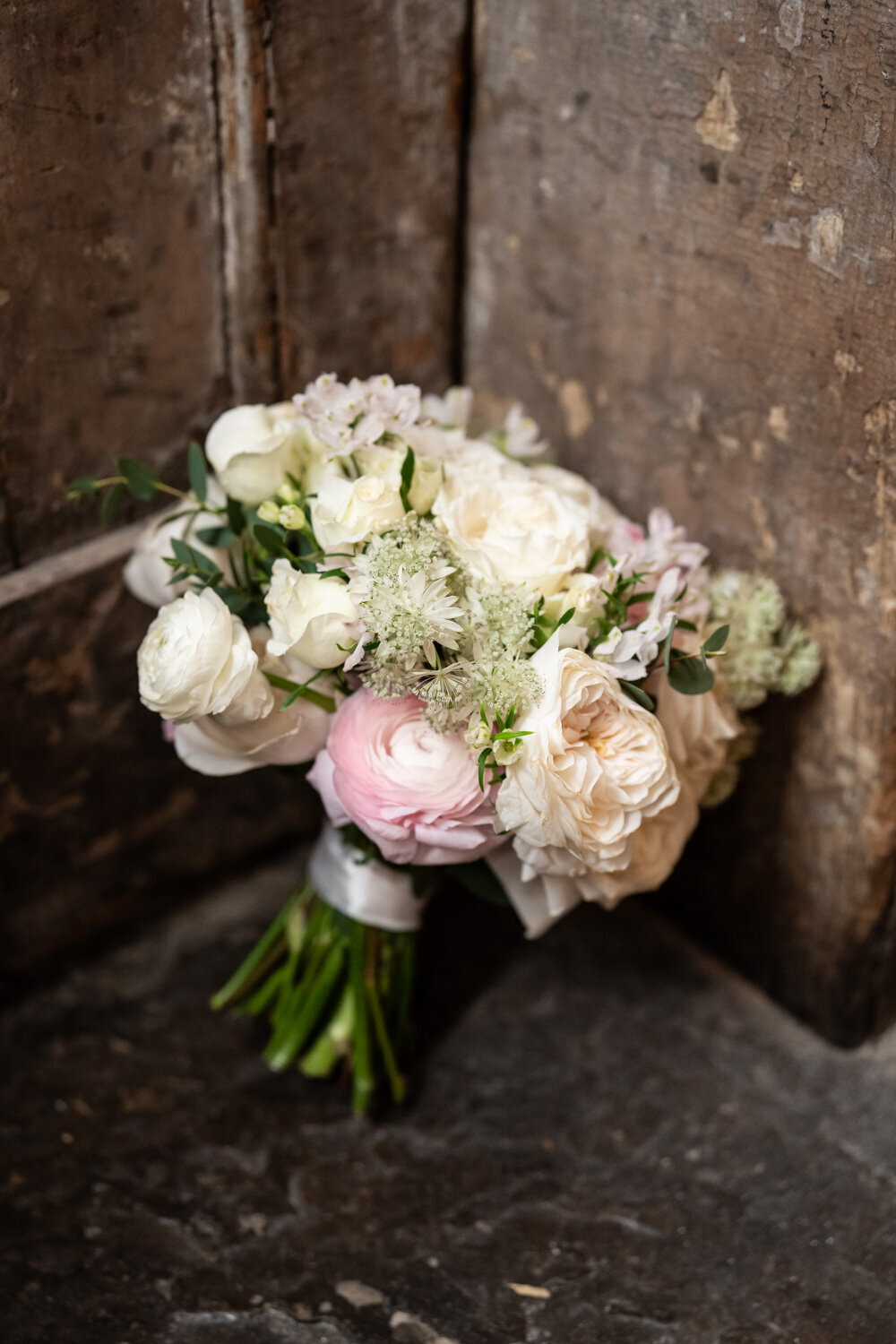 Brides bouquet resting against wall