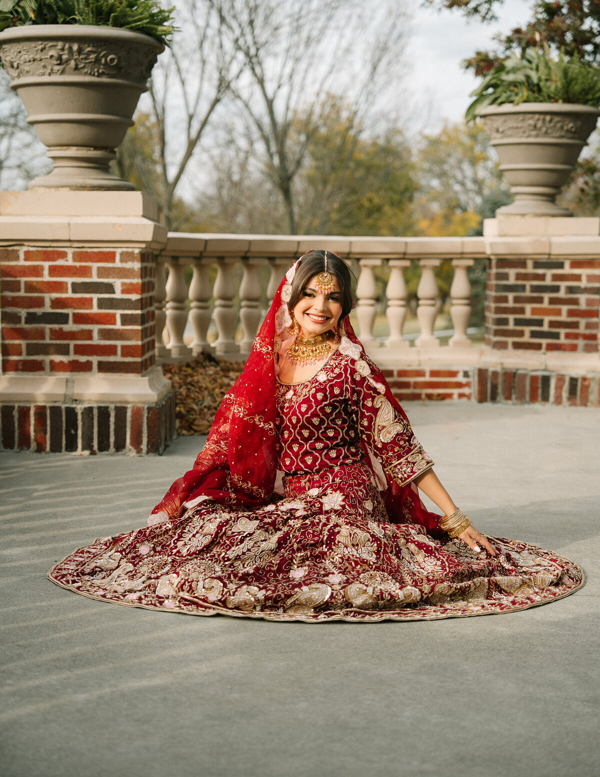 Indian Bride sits on the ground showing the detail of her sari