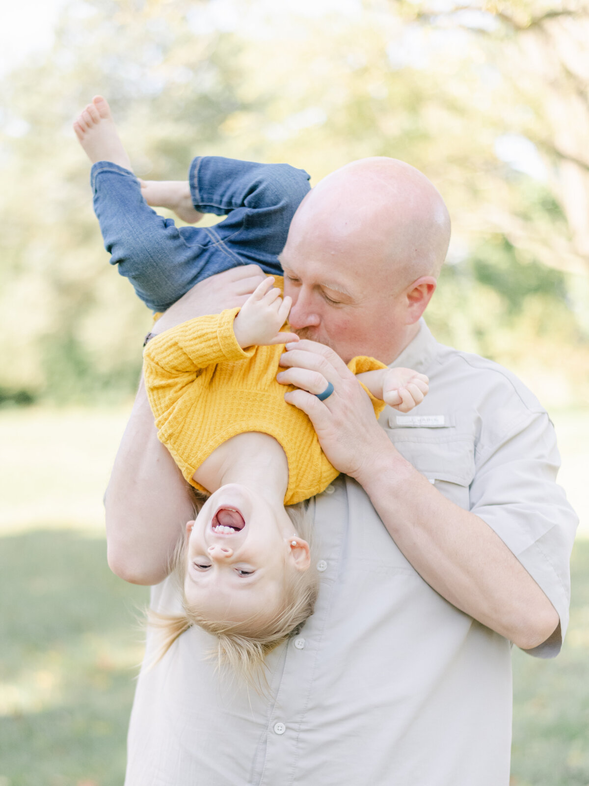 Dad and young daughter hanging upside down during a maternity session in Richmond.