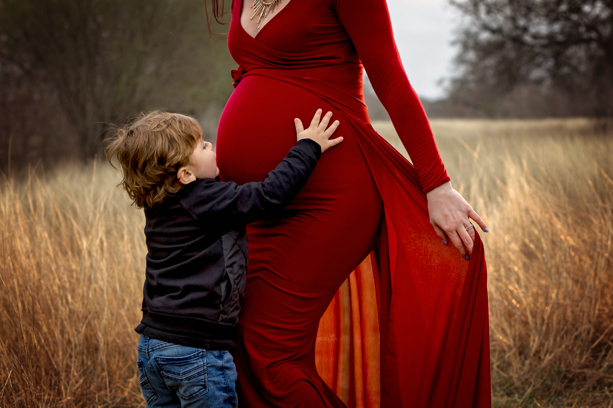 Glow in style with our winter maternity session near San Antonio. Laid-back parents, our mom-to-be's scarlet flying dress adds warmth and elegance to your family memories.