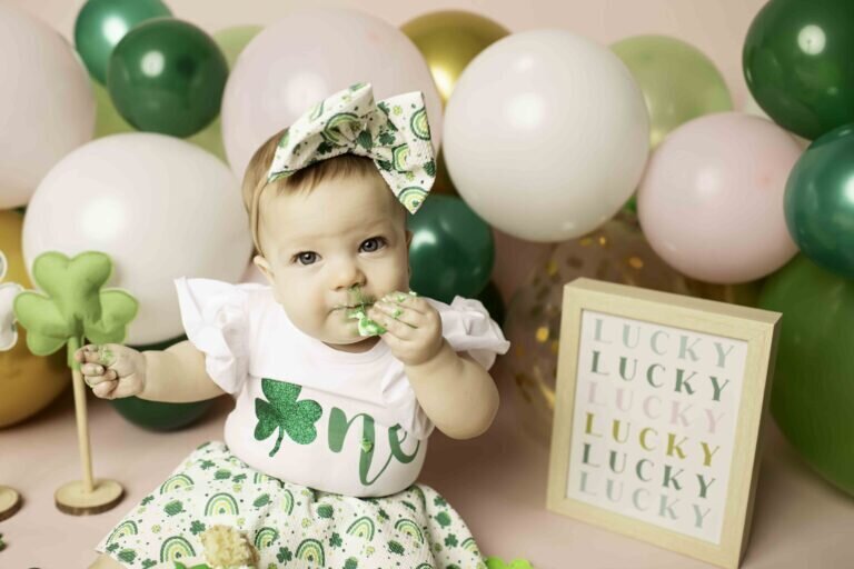 One-year-old girl in a cute tutu dress, sitting next to a birthday cake, ready for her first birthday photoshoot