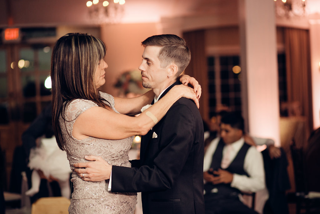 Wedding Photograph Of Groom In Black Suit Dancing With A Woman Side View Los Angeles