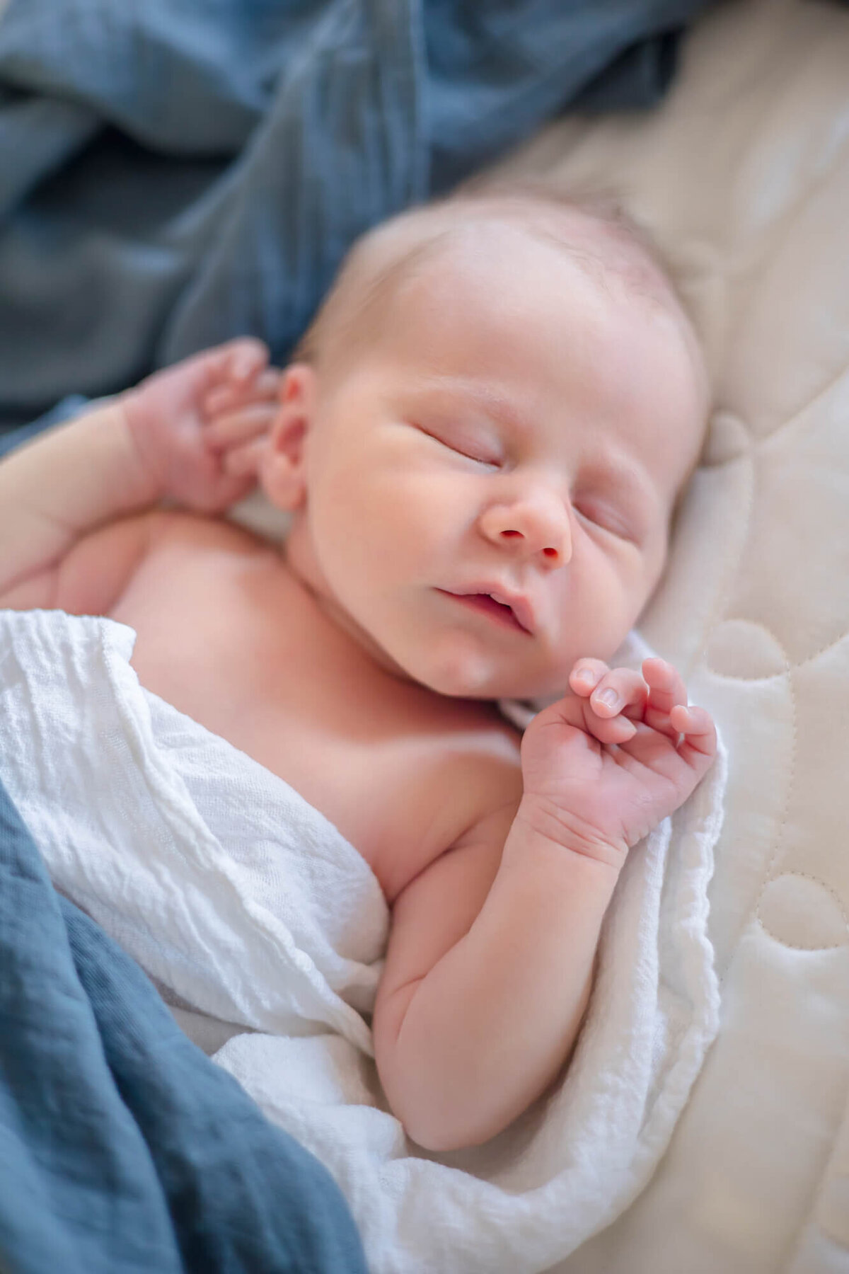 sweet newborn baby boy sleeping with hands near his favce