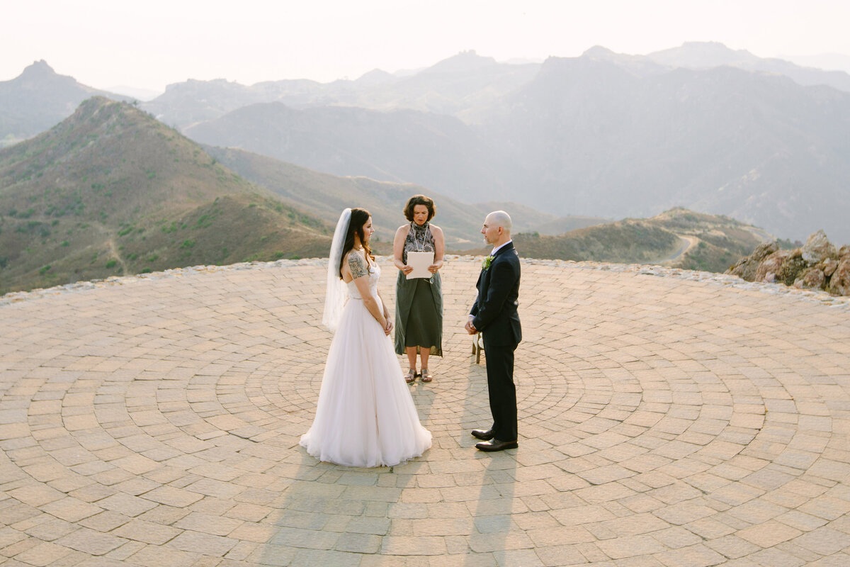 bride and groom stand on helicopter pad during an elopement ceremony