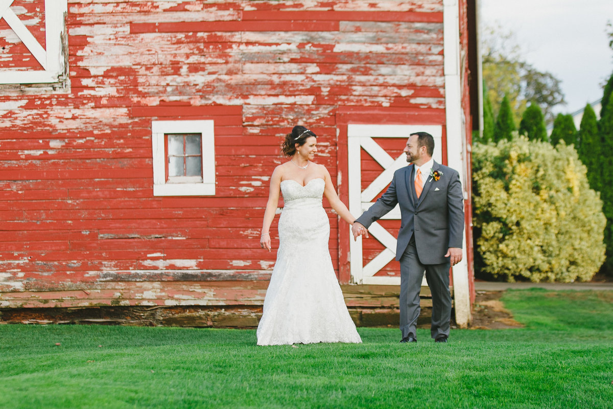 photo of bride and groom walking in front of a barn at Langdon Farms | Susie Moreno Photography