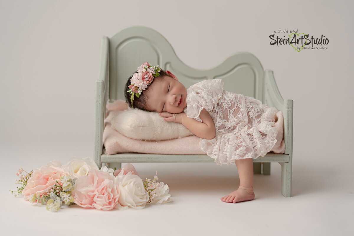 Newborn girl sleeping on a mini couch
