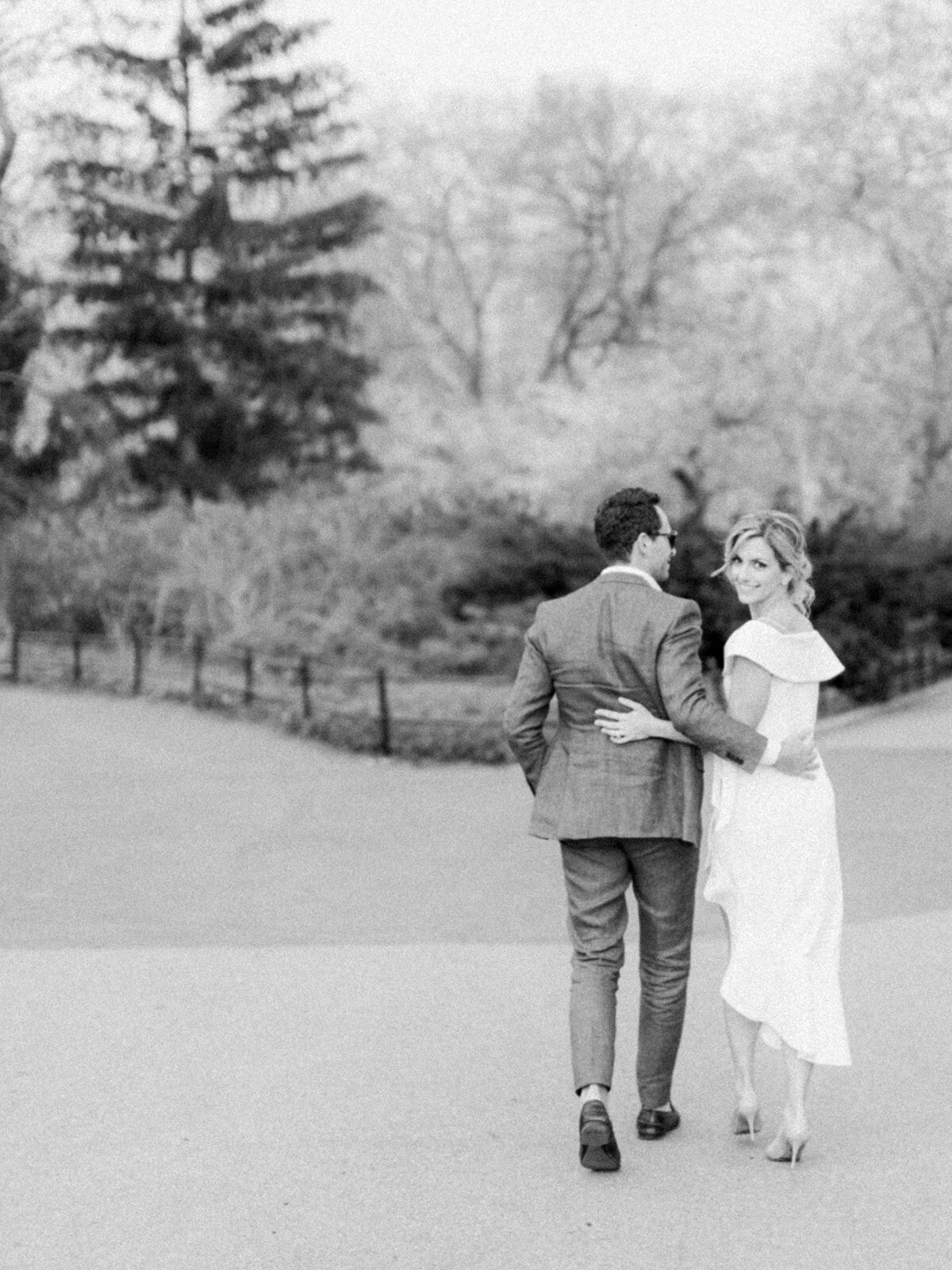 Bride and groom stroll through a park