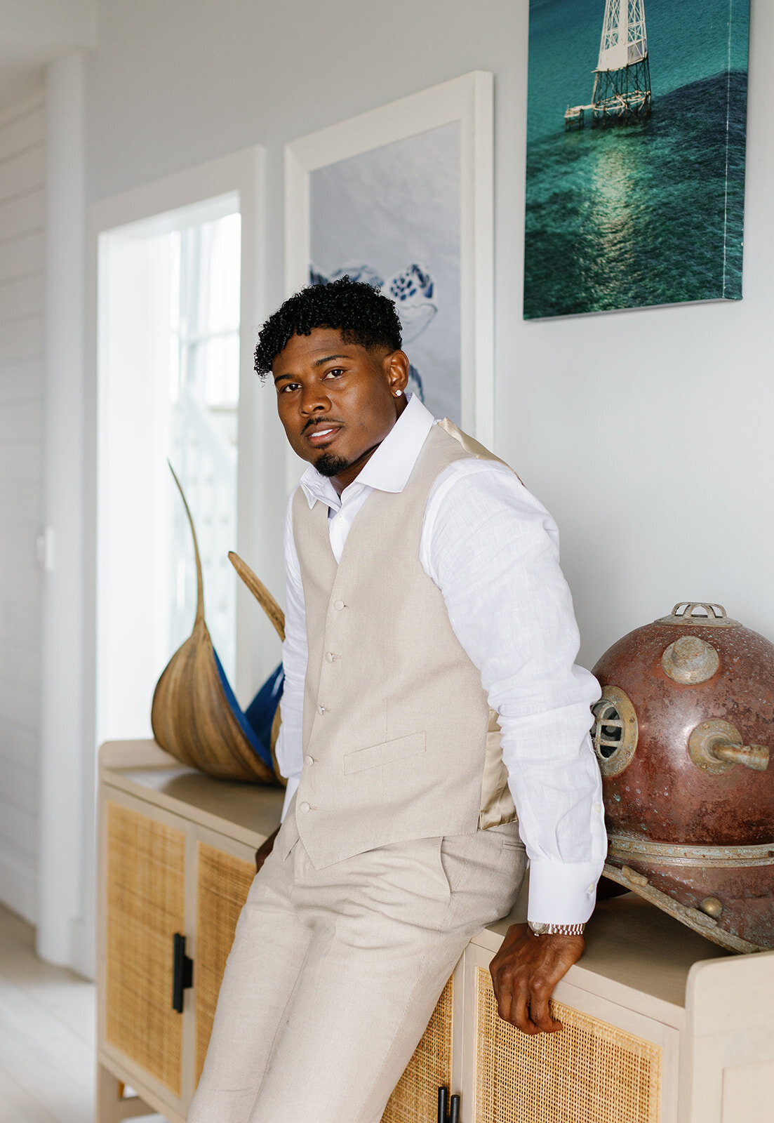 Groom Jonathan in a beige suit, posing confidently in a modern beachside setting at Table Key, Islamorada. Captured by Claudia Amalia Wedding Photography.