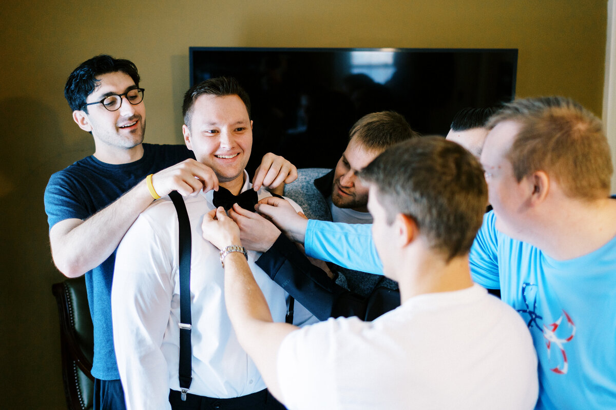 Groomsmen helping with the bowtie