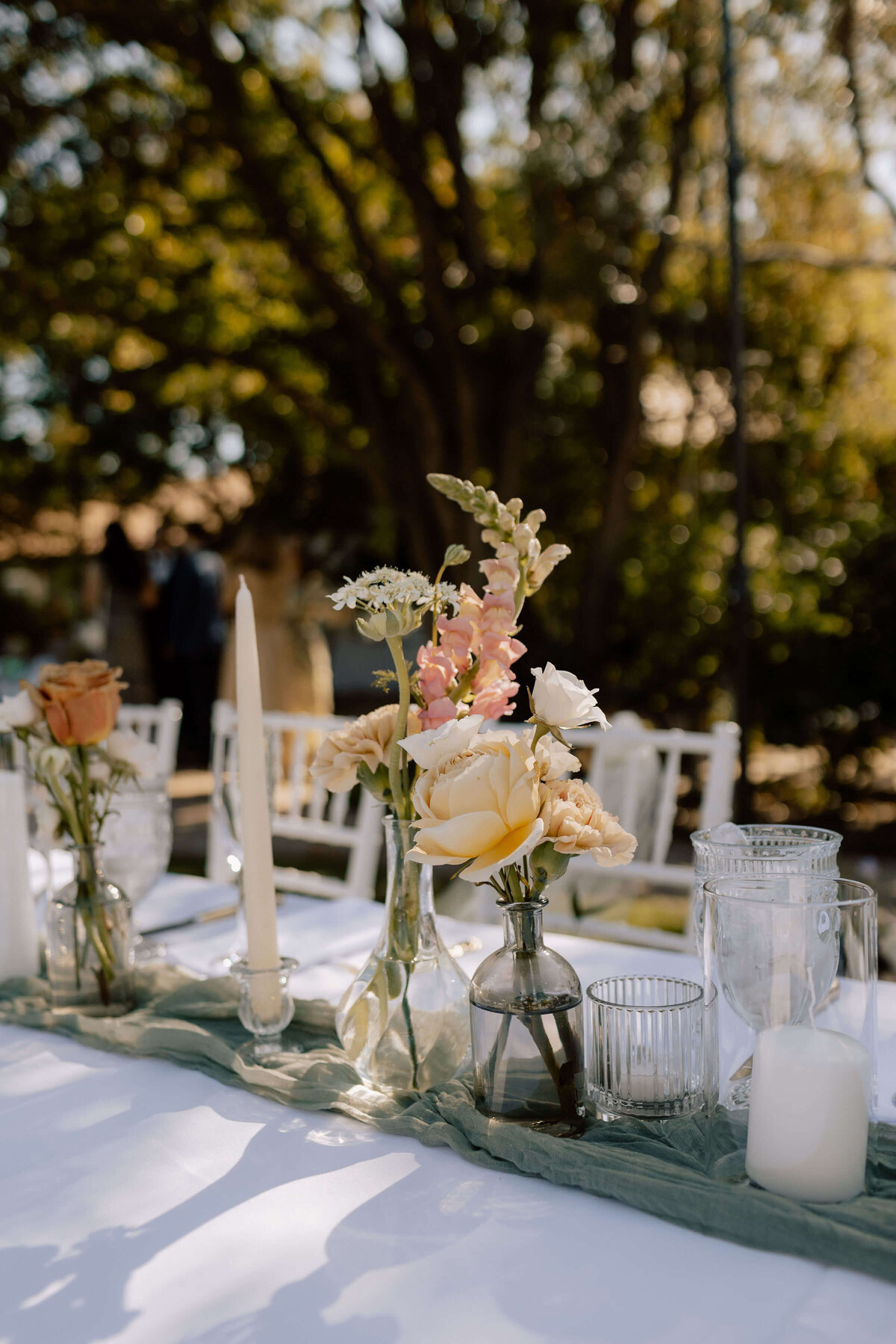 Catholic wedding tablescape with flowers in vases and tall candles