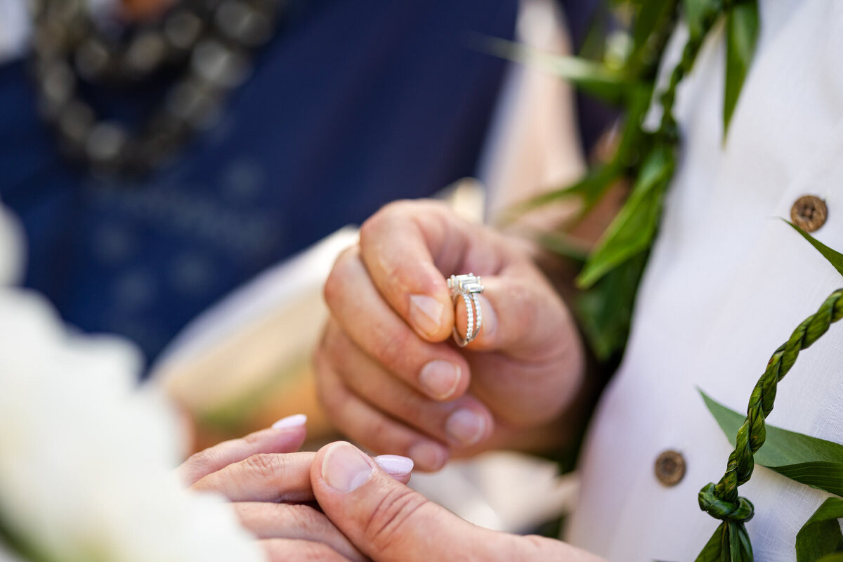 groom puts wedding ring on bride during wedding ceremony