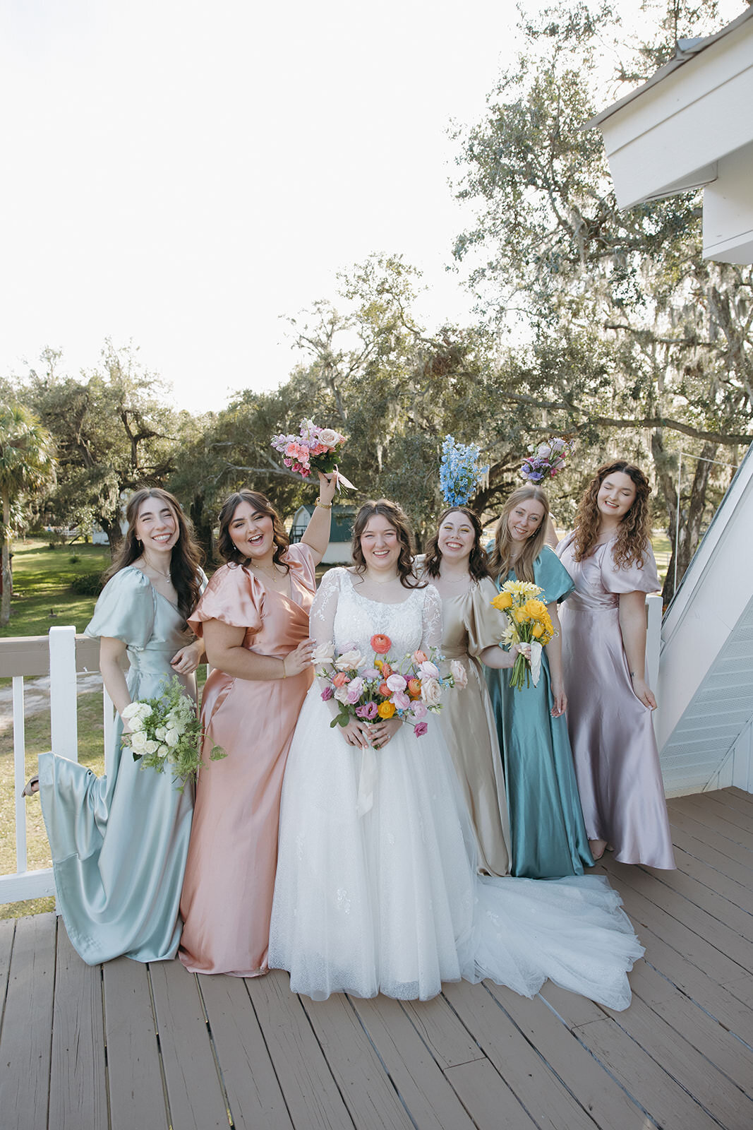 Wedding party smiling by the outdoor steps at Uliana Estate, a charming Lakeland wedding venue.

