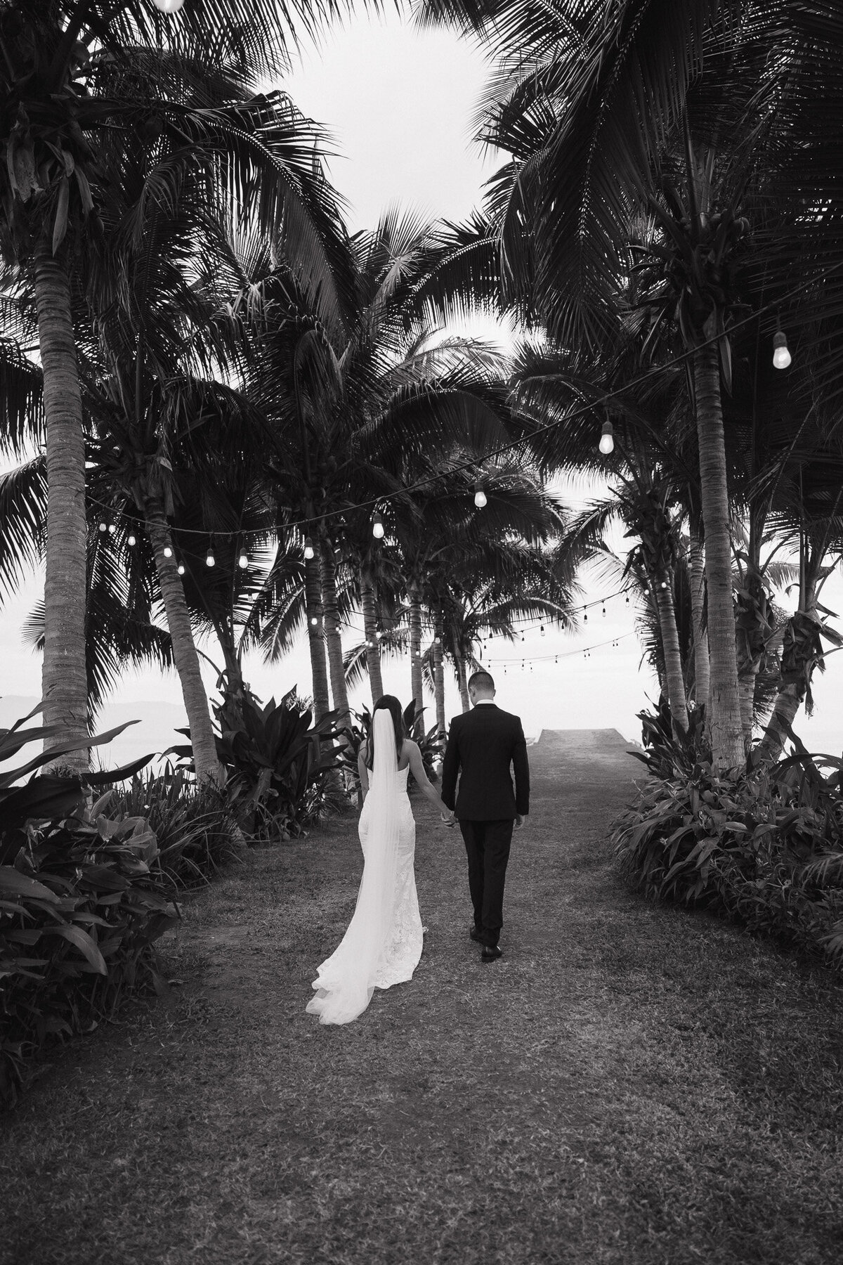Luxury wedding photography by Kansas photographer Staci Brucks featuring bride and groom walking hand in hand through scenic landscape