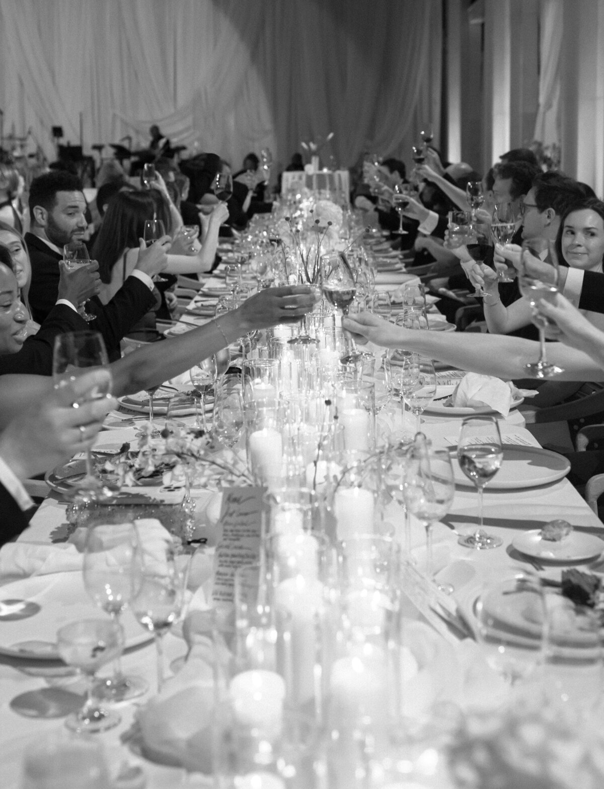 soft documentary film wedding photo of guests toasting over candlelit tables at State Savings Bank, Detroit