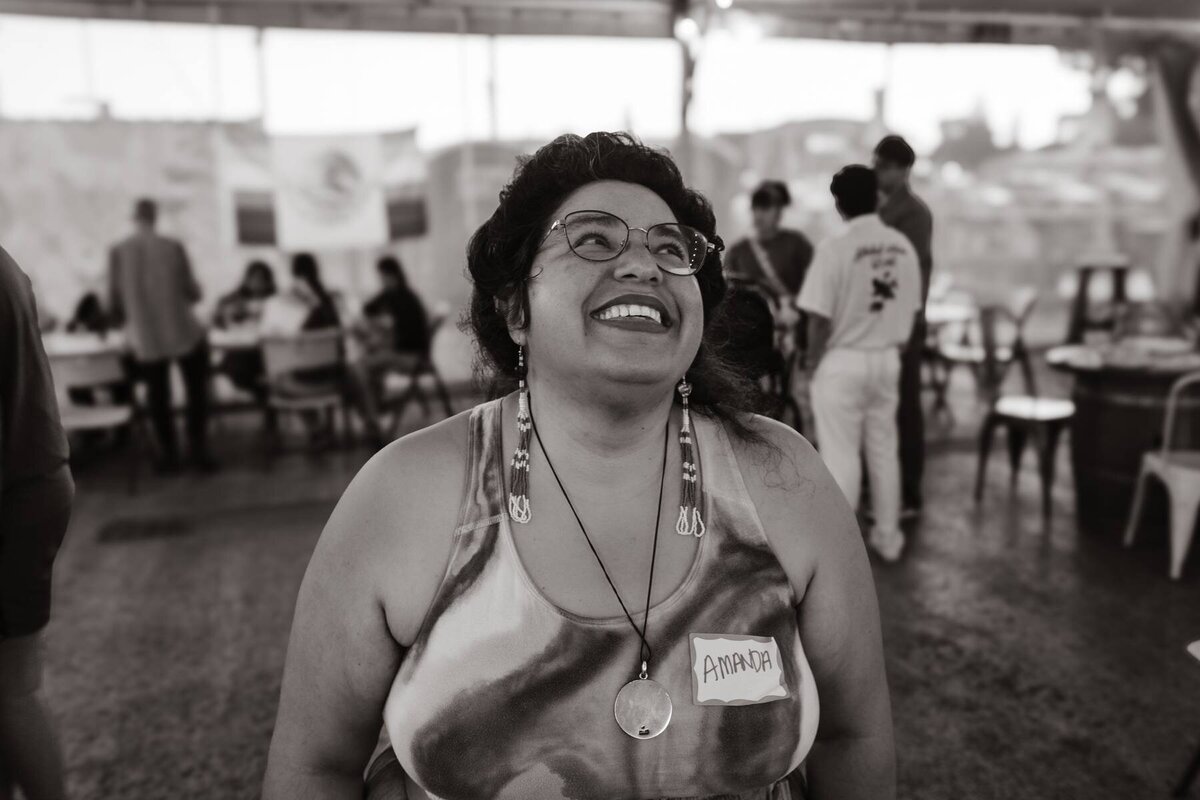 A person smiling looking up to the right at an event