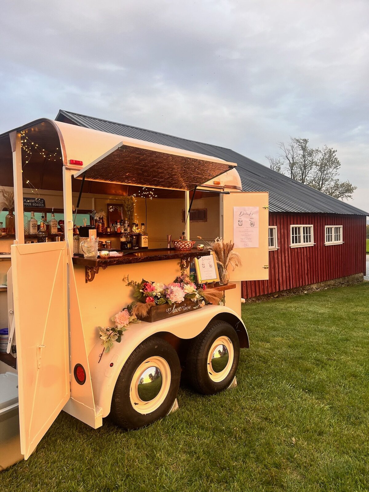 Horse trailer mobile bar sits in front of barn on farm