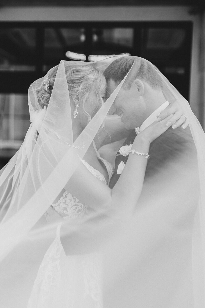 Bride and groom under veil infront of Hotel Fort Des Moines